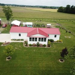 Farm house with red metal roof by Bontrager Roofing LLC